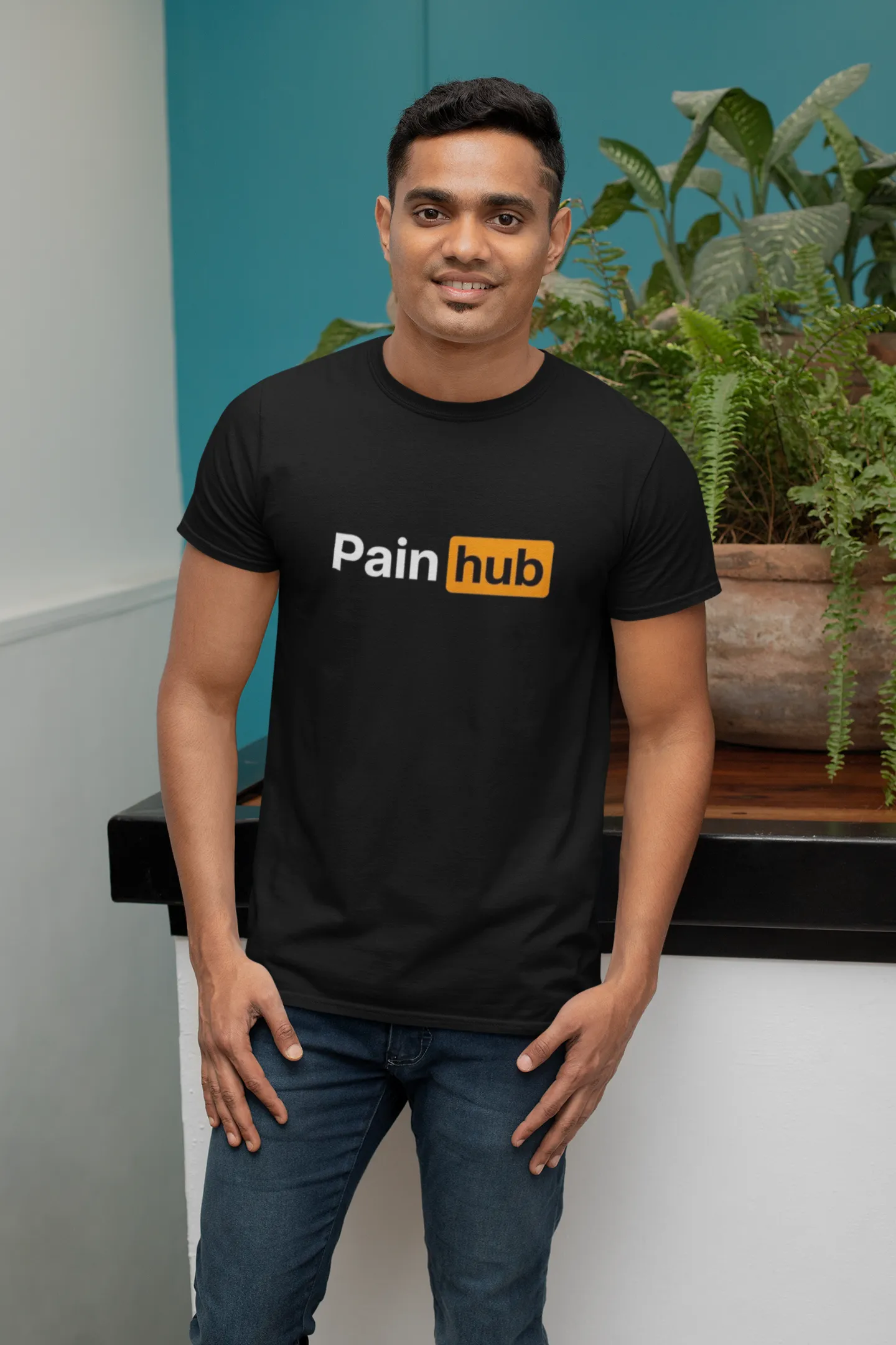 mockup-of-a-man-with-a-t-shirt-posing-next-to-a-plant-28956 (1) Pain Hub - Round Neck - Image 1